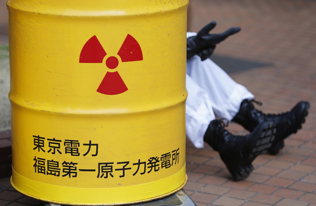 An anti-nuclear protester wearing a protective suit is seen behind a mock drum which is labelled as radioactive waste from Tokyo Electric Power Co's (TEPCO) Fukushima nuclear power plant, before he starts marching in Tokyo March 9, 2014. Thousands of protesters marched in the Japanese capital on Sunday, ahead of the third anniversary of an earthquake and tsunami that triggered the world's worst atomic disaster in 25 years. REUTERS/Yuya Shino (JAPAN - Tags: ANNIVERSARY DISASTER ENERGY CIVIL UNREST) - GM1EA391B1F01