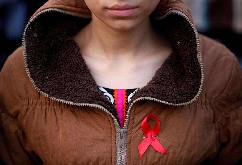 A participant with a red ribbon pin takes part in a HIV/AIDS awareness campaign ahead of World Aids Day, in Kathmandu, Nepal