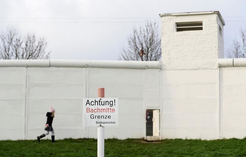 A girl walks at a former border crossing between Eastern and Western Germany during an event marking the 30th anniversary of the fall of the Berlin Wall in the former border village of Moedlareuth, Germany November 9, 2019. REUTERS/David W Cerny - RC2Q7D93B0V3