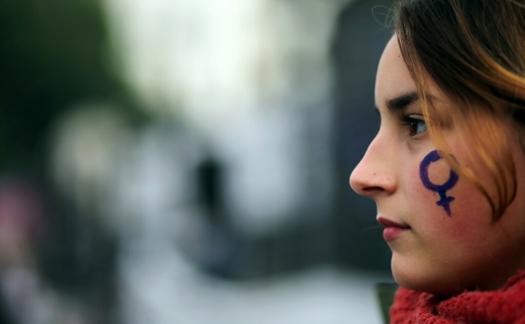 A woman has the symbol for women painted on her face during a protest against femicides and violence against women in Buenos Aires, Argentina, June 3, 2017. REUTERS/Marcos Brindicci - RC1C5A493B60