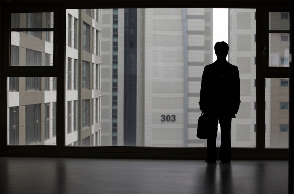 Kim Keon-hoon, a worker with Byucksan Engineering & Construction, looks out through the window from his empty two-bathroom, four-bedroom apartment before an interview with Reuters, in the middle class suburb in Goyang, north of Seoul April 1, 2013.