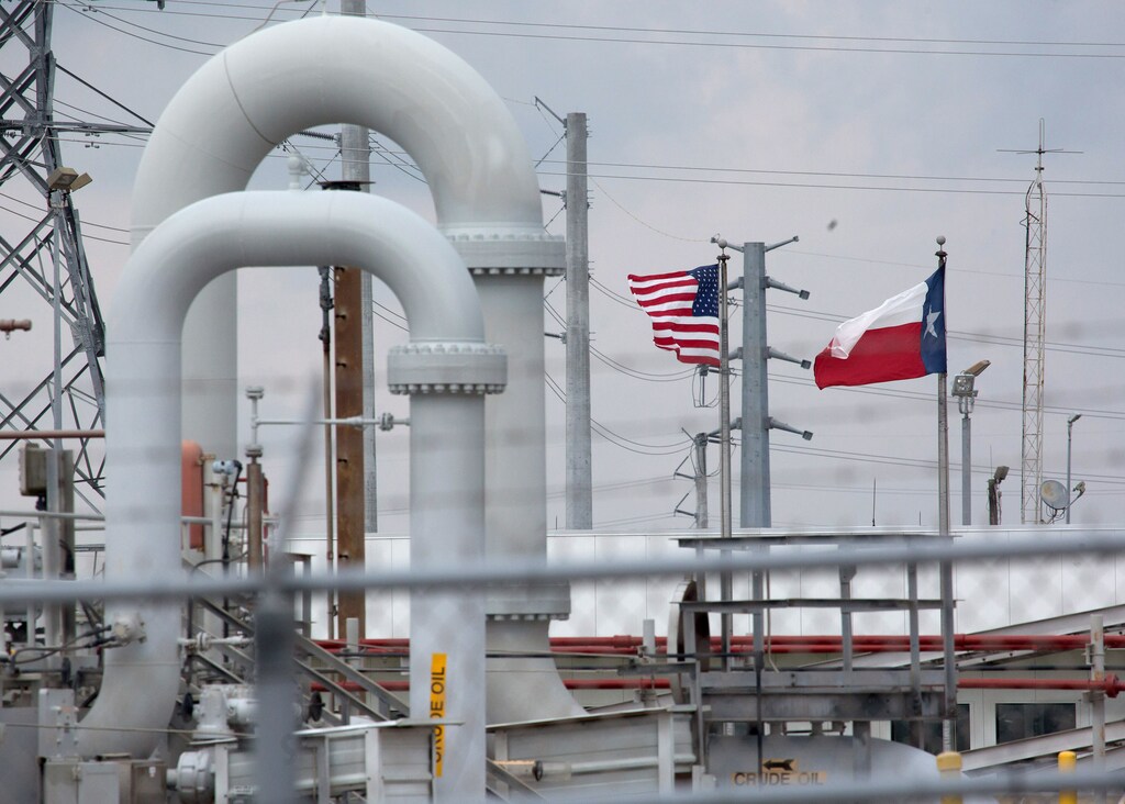 A maze of crude oil pipe and equipment is seen with the American and Texas flags flying in the background during a tour by the Department of Energy at the Strategic Petroleum Reserve in Freeport, Texas, U.S. June 9, 2016. REUTERS/Richard Carson - RTSGTQ5