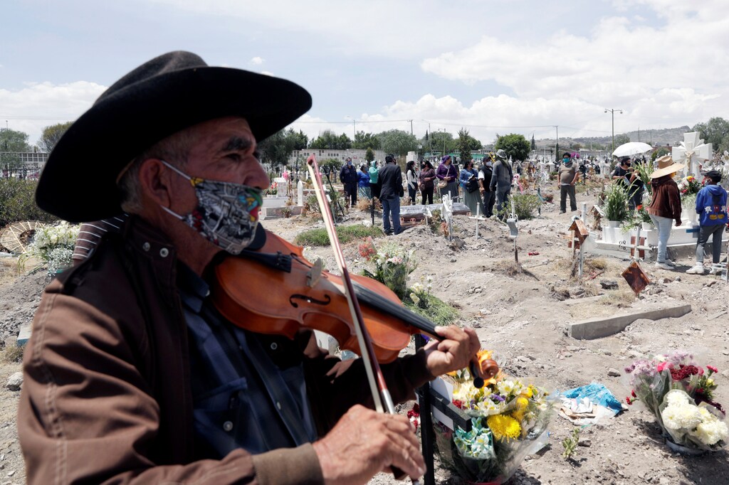 Un músico toca su instrumento durante el entierro de dos personas, que murieron de la enfermedad coronavirus (COVID-19), en el cementerio municipal de San Isidro, mientras continúa el brote de la enfermedad coronavirus (COVID-19), en Ecatepec de Morelos , en las afueras de la Ciudad de México, México 19 de junio de 2020.