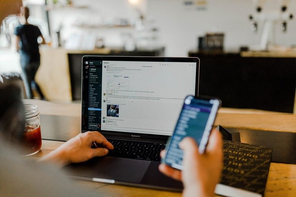 A person communicating on both their phone and mobile.
