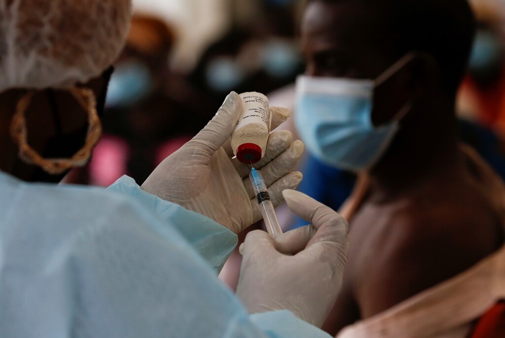A health worker prepares to vaccinate a resident as the vaccinations against Ebola continue in Alakro