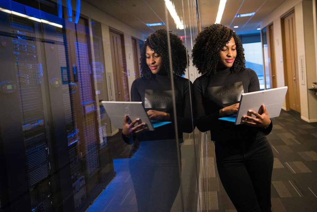 side view of a Black businesswoman holding a laptop and her reflection in a blog about Africa
