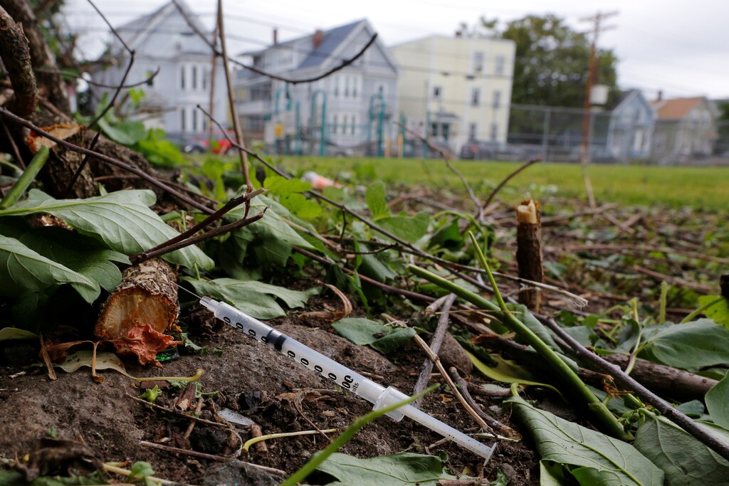 A used needle sits on the ground in a park in Lawrence, Massachusetts, U.S., May 30, 2017, where individuals were arrested earlier in the day during raids to break up heroin and fentanyl drug rings in the region, according to law enforcement officials. REUTERS/Brian Snyder - RTX38AHC