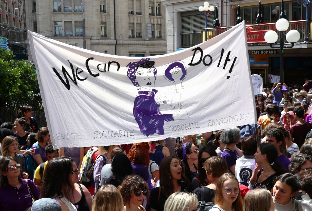 People hold a banner during a day-long and nationwide women's strike aimed at highlighting the country's poor record on defending the rights of women and families in Lausanne, Switzerland, June 14, 2019. REUTERS/Denis Balibouse - RC1700A6F0B0