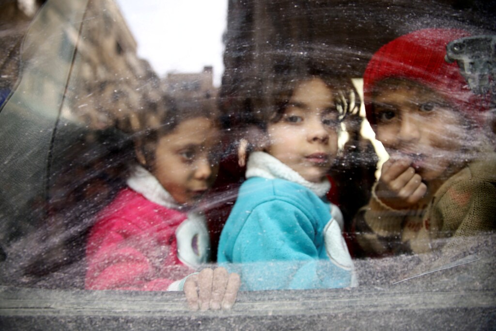 Children look through a bus window during evacuation from the besieged town of Douma, Eastern Ghouta, in Damascus, Syria March 13, 2018. REUTERS/Bassam Khabieh TPX IMAGES OF THE DAY - RC1A80480B00