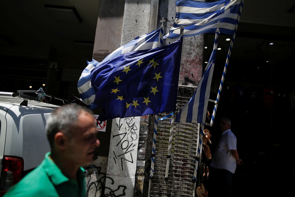 Greek national flags and a European Union flag flutter outside a shop in central Athens, Greece July 6, 2017. REUTERS/Alkis Konstantinidis - RTX3A9ZD