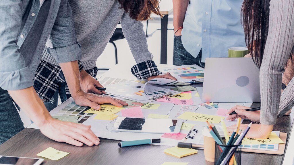 Close up creative designer applaud for job success at meeting table at office; scaling start-ups