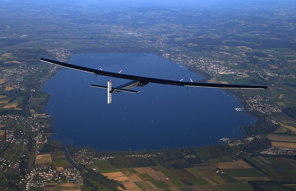 German test pilot Markus Scherdel steers the solar-powered Solar Impulse 2 aircraft over the Lake Murten during a training flight at its base in Payerne September 27, 2014. The aircraft, which was unveiled April 9, weighs 2.4 tons with a wingspan of 72 meters (236 ft.) and has more than 17,000 solar cells. The attempt to fly around the world in stages using only solar energy will be made from March 2015 starting from Abu Dhabi.