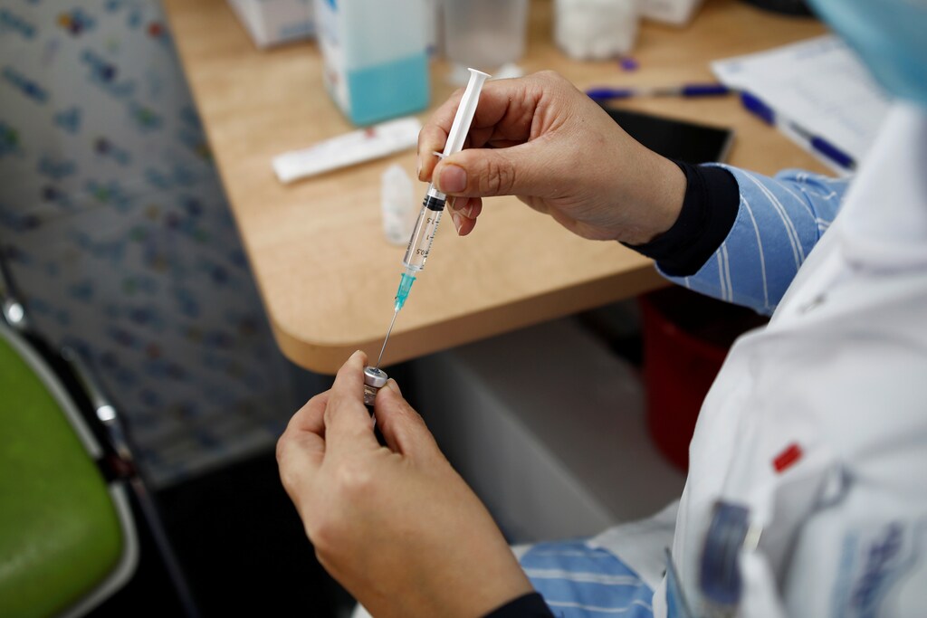 image of a medical worker preparing to administer a vaccination against COVID-19
