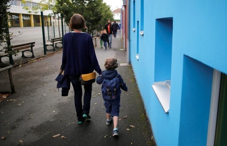A mother and her son walk to arrive at the nursery school on the first day of the new school year in Vertou, France, September 4, 2017. REUTERS/Stephane Mahe