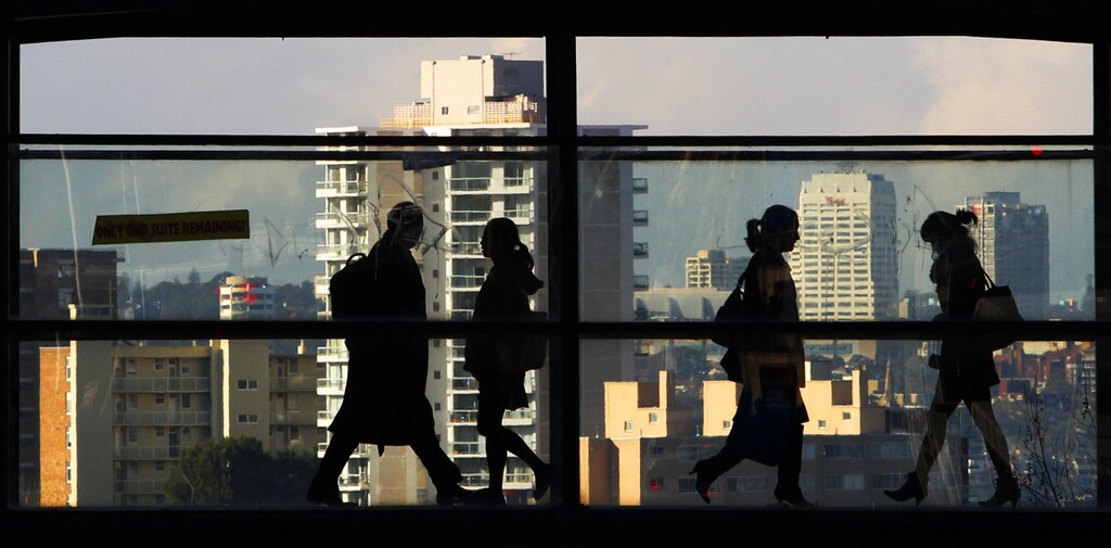 Peak-hour commuters walk across a glass walled bridge between office buildings in Sydney July 27, 2011. Australian consumer prices rose by more than expected last quarter while key measures of underlying inflation were alarmingly high, reviving pressure foran increase in interest rates and lifting the local dollar to a 29-year peak. REUTERS/Tim Wimborne (AUSTRALIA - Tags: BUSINESS) - GM1E77R0RW101