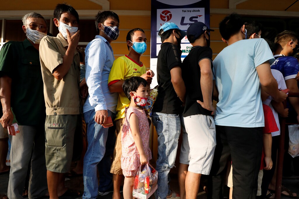 Soccer fans wearing protective masks line up before entering for a soccer match between Viettel and Duoc Nam Ha Nam Dinh of the V.League, the national soccer league, after the Government eased nationwide lockdown following the coronavirus disease (COVID-19) outbreak in Nam Dinh province, Vietnam June 5, 2020. REUTERS/Kham - RC223H98XD33
