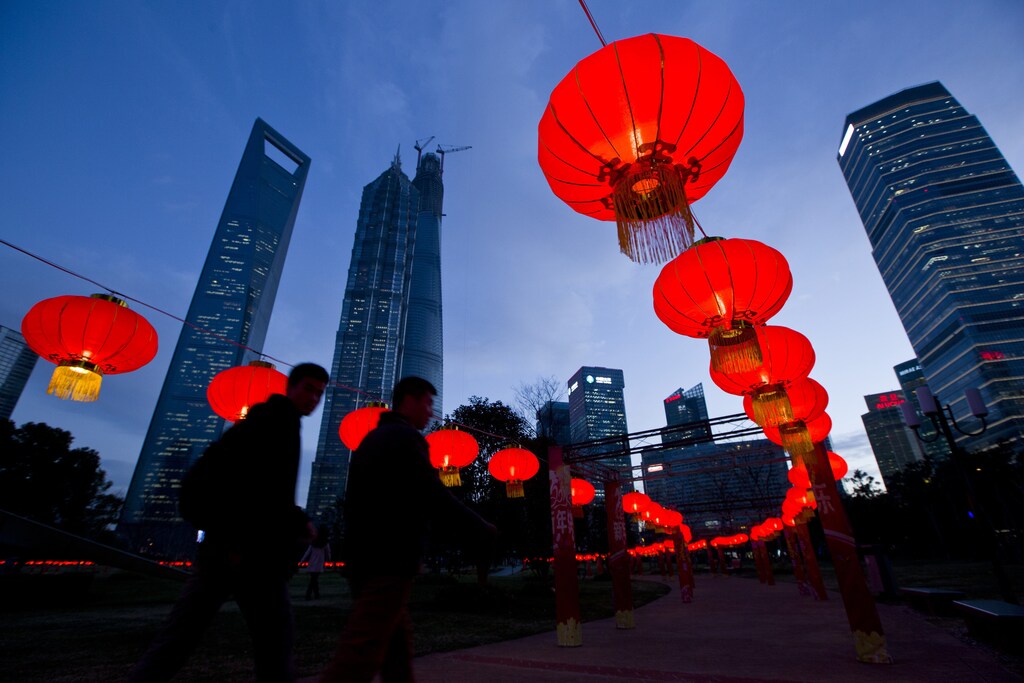 Pedestrians walk under red lanterns which was recently installed as Chinese New Year decorations, at Pudong Financial Area in Shanghai, January 24, 2014. According to the Chinese lunar calendar, the Chinese New Year, which welcomes the year of the horse, kicks off on January 31. Picture taken January 24, 2014. REUTERS/Aly Song (CHINA - Tags: ANNIVERSARY BUSINESS SOCIETY) - RTX17TDG
