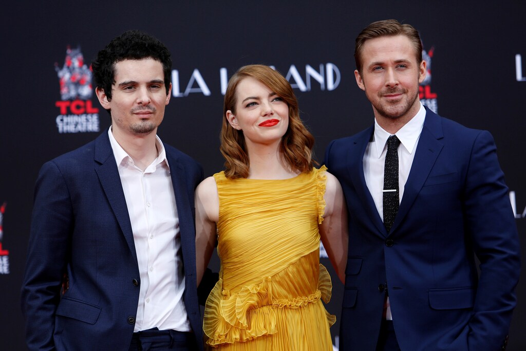 Director Damien Chazelle (L) poses with actors Emma Stone and Ryan Gosling after they placed their handprints, footprints and signatures in cement during a ceremony in the forecourt of the TCL Chinese theatre in Hollywood, California U.S., December 7, 2016. REUTERS/Mario Anzuoni - RTSV5N3