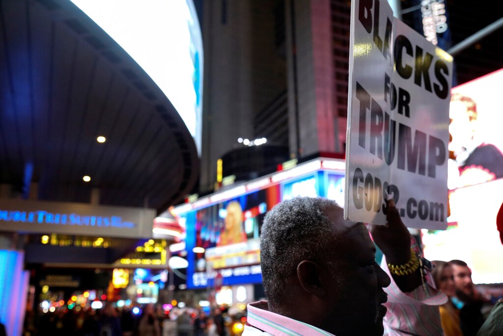A supporter of U.S. President-elect Donald Trump holds a sign in Times Square, Manhattan, New York, U.S. on November 8, 2016. REUTERS/Bria Webb - RTX2SQDS