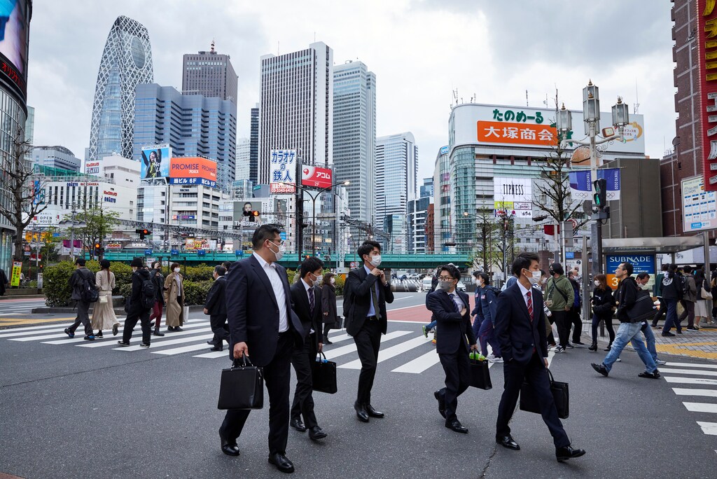 Passersby wearing protective masks during the COVID-19 pandemic walk on the street at Shinjuku district in Tokyo, Japan April 6, 2021.