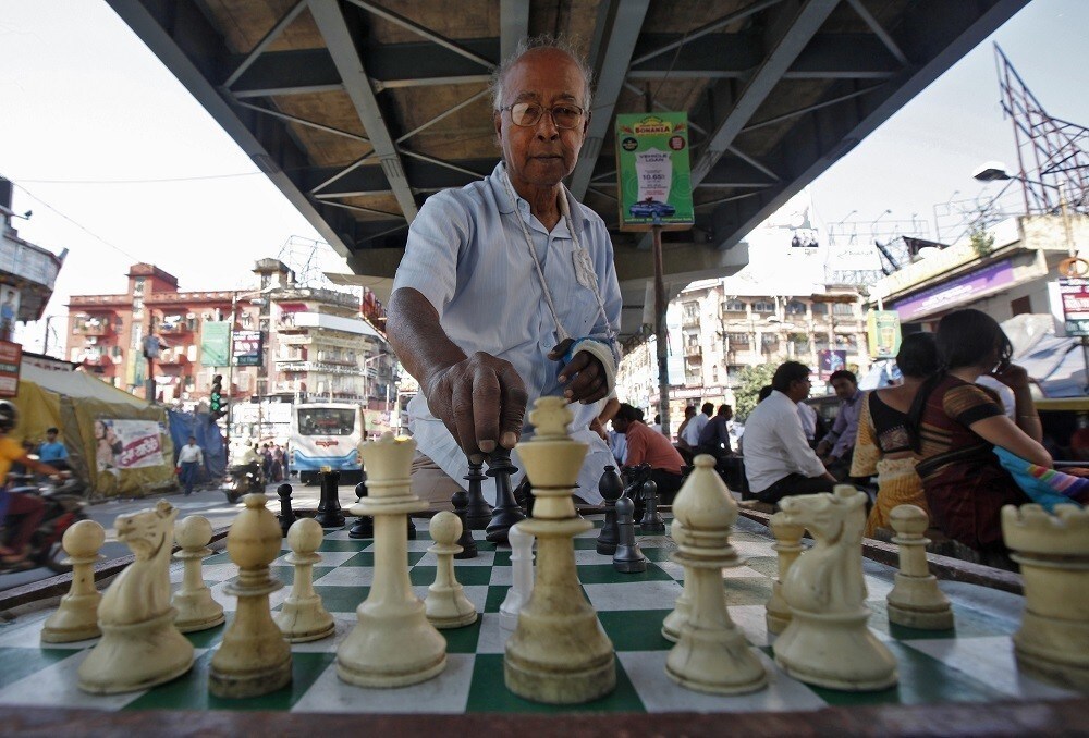 Amlandu Saha, 75, arranges chess before starting to play at an open air street chess club at Gariahat Boulevard in Kolkata November 11, 2013. According to the club's members, everyday dozens of people wait for hours for their turn to play a game of chess after finishing their day's work. With India having overtaken France as the nation with the most players rated by the World Chess Federation, the country that invented the predecessor of the strategic game is finally proving to be a hotbed of chess talent. REUTERS/Rupak De Chowdhuri (INDIA - Tags: SPORT CHESS SOCIETY) - RTX1597P