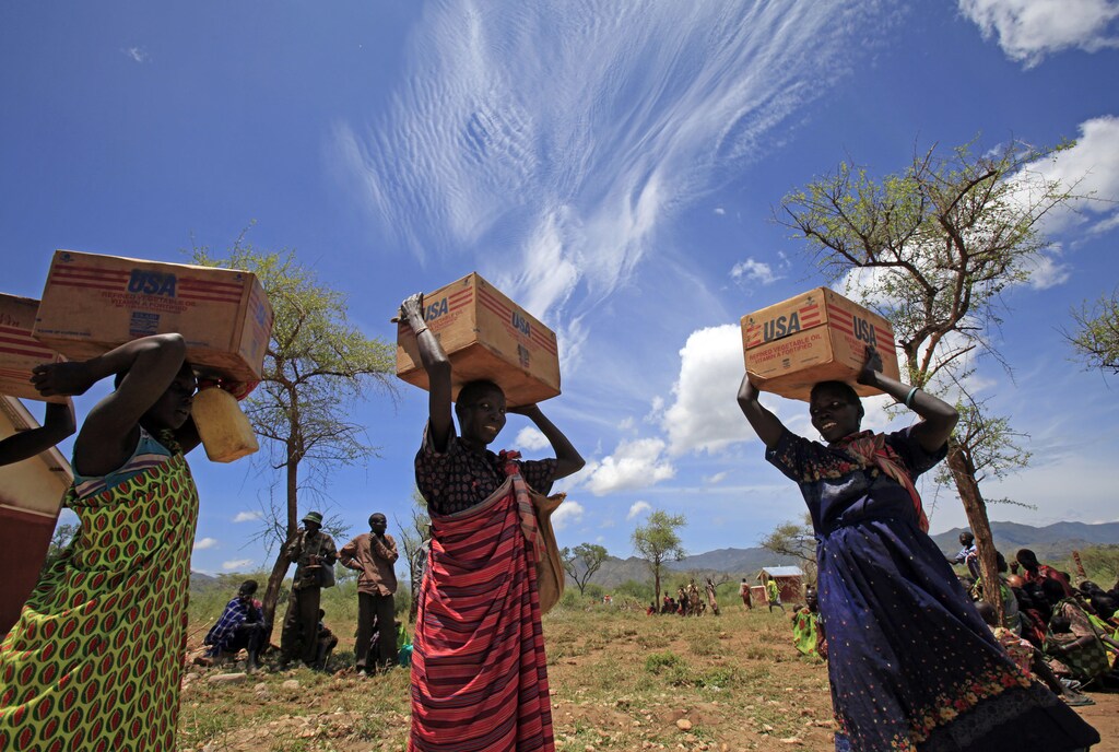 Women from Dadinga tribe carry boxes of oil during food distribution by World Food Program (WFP) in the village of Lauro, Budy county, in Eastern Equatoria State, south Sudan, April 3, 2010. REUTERS/Goran Tomasevic (SUDAN - Tags: SOCIETY POLITICS FOOD) - GM1E6431T2D01