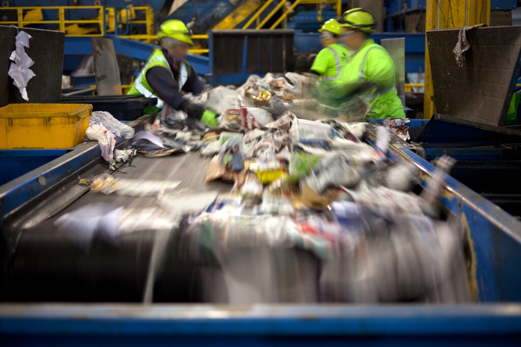 Workers separating paper and plastic on a conveyor belt in a recycling facility: Does extended producer responsibility (EPR) have a place in the global plastics treaty?