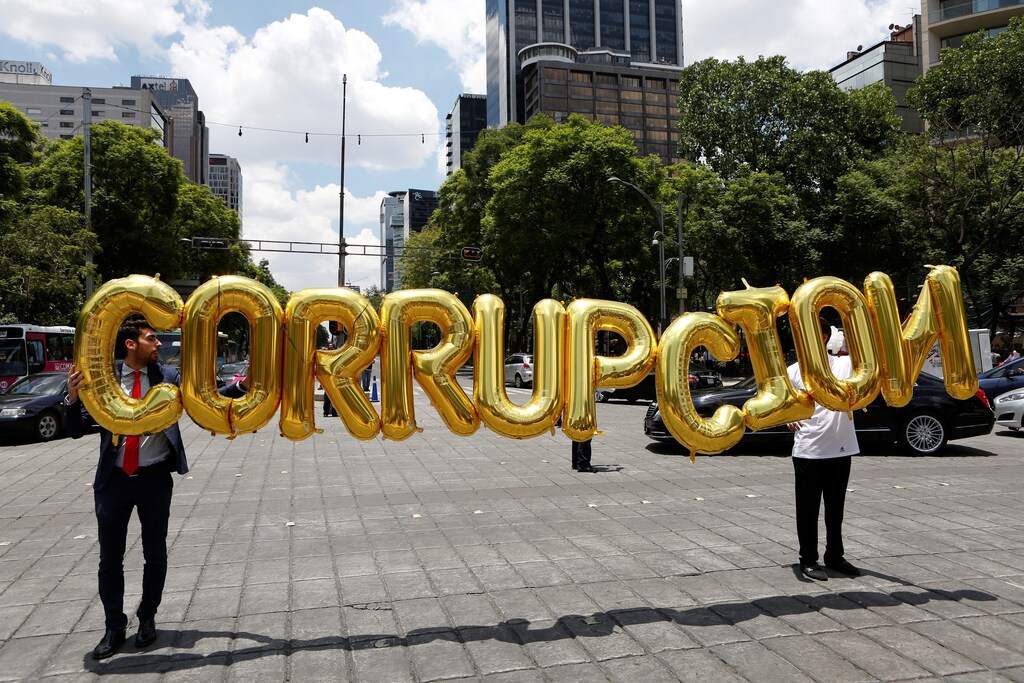 Businessmen hold balloons forming the word that reads 'Corruption' during a protest by members of the Mexican Employers' Confederation (COPARMEX) to demand senators to approve the original proposal of the National Anticorruption System, at the Angel of Independence monument in Mexico City, Mexico, June 16, 2016.
