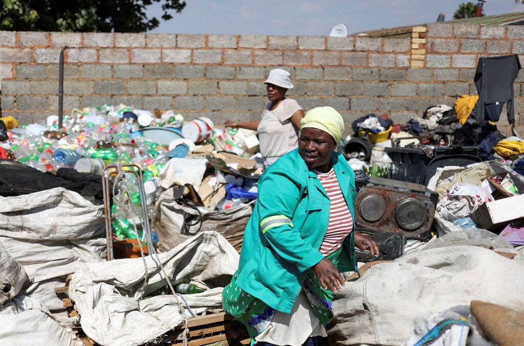 Waste pickers Abigail Kubheka and Adelina Nkopane sort out recyclable material amid the spread of the coronavirus disease (COVID-19) in Soweto, near Johannesburg, South Africa, April 20, 2020. Picture taken April 20, 2020. REUTERS/Siphiwe Sibeko - RC28AG9QMUEL