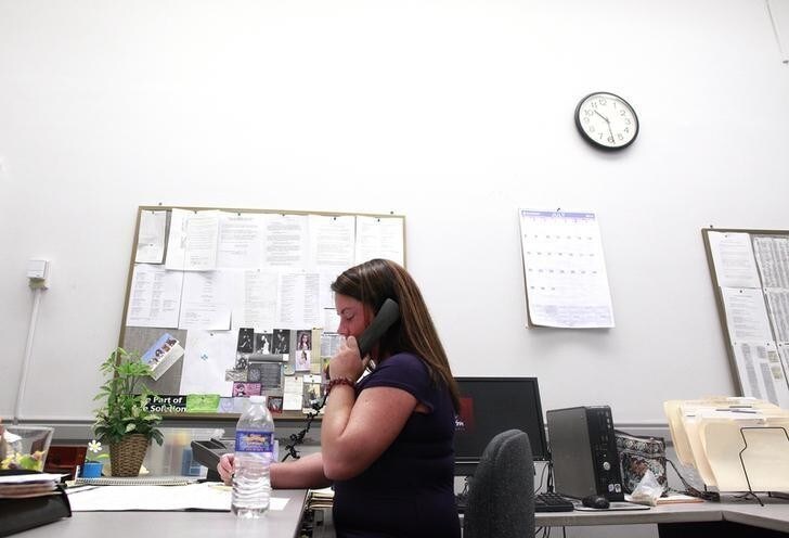 A worker answers the phone in the City Council's office at city hall in Scranton, Pennsylvania July 12, 2012. Firefighters, police officers and public works employees in Scranton sued the city Tuesday after the mayor slashed pay for the city's workers to the state's minimum wage of $7.25 an hour. Scranton, a city of about 76,000 in the northeast of the state, is the latest U.S. city in financial turmoil amid sunken revenue collections, lowered state aid and increased pension and other costs. REUTERS/Eric Thayer (UNITED STATES - Tags: POLITICS BUSINESS EMPLOYMENT CIVIL UNREST)