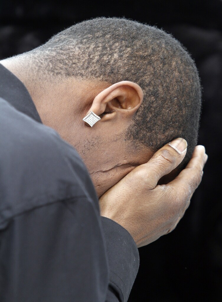 A mourner reacts outside of New Mount Pilgrim Missionary Baptist Church after the funeral of Bettie Jones in Chicago, Illinois, January 6, 2016. Hundreds of people attended the funeral at a Chicago church for Bettie Jones, who was fatally shot in late December after police responded to a call about a neighbor's son threatening his father with a baseball bat. . REUTERS/Frank Polich - RTX21BEG