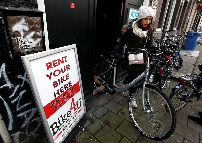 A tourist rents a bicycle in central Amsterdam, Netherlands, December 1, 2017. REUTERS/Yves Herman - RC1BA8AD0AB0