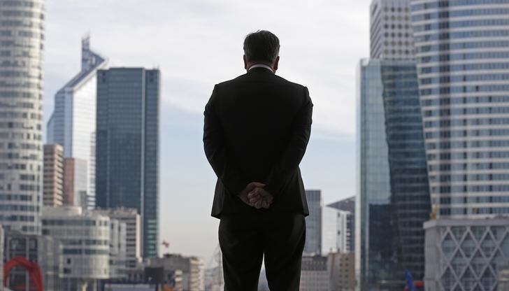 A Businessman is silhouetted as he stands under the Arche de la Defense, in the financial district west of Paris, November 20, 2012. France said its economy was sound and reforms were on track after credit ratings agency Moody's stripped it of the prized triple-A badge due to an uncertain fiscal and economic outlook. Monday's downgrade, which follows a cut by Standard & Poor's in January, was expected but is a blow to Socialist President Francois Hollande as he tries to fix France's finances and revive the euro zone's second largest economy. REUTERS/Christian Hartmann (FRANCE - Tags: POLITICS BUSINESS)