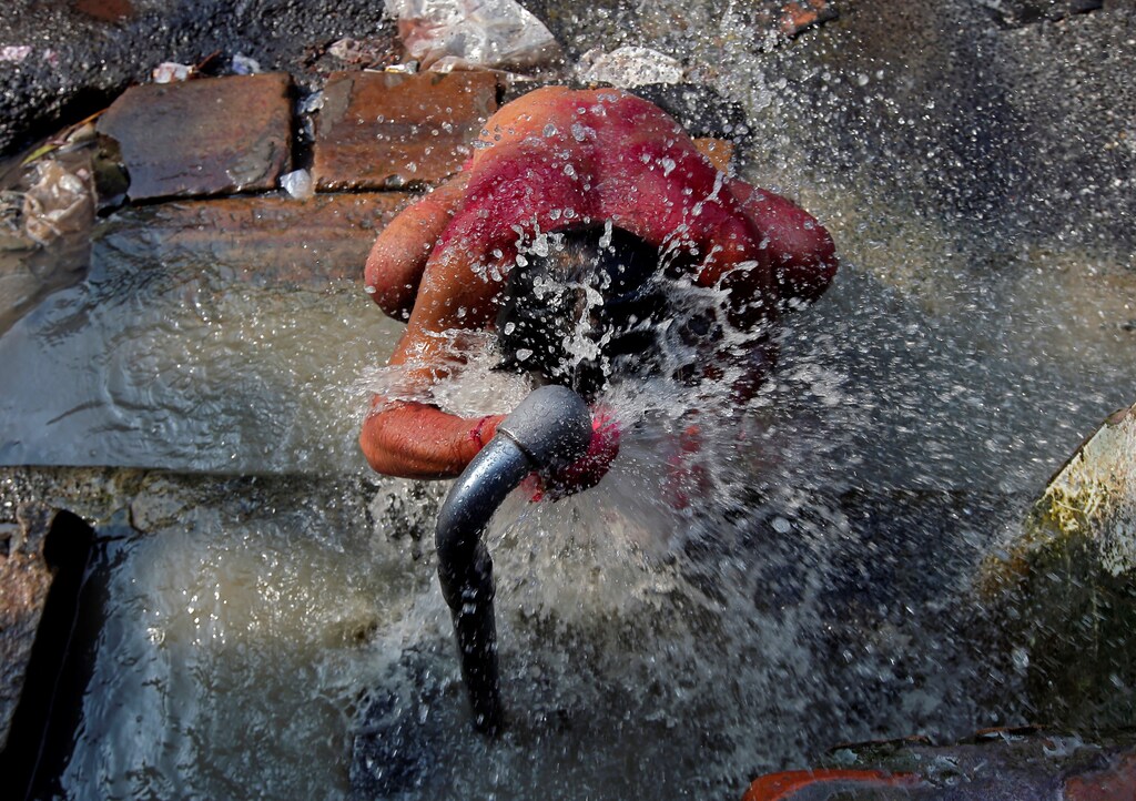 A man bathes at a roadside municipal tap in a market area of Kolkata, India, March 22, 2019. REUTERS/Rupak De Chowdhuri - RC140F81D9B0
