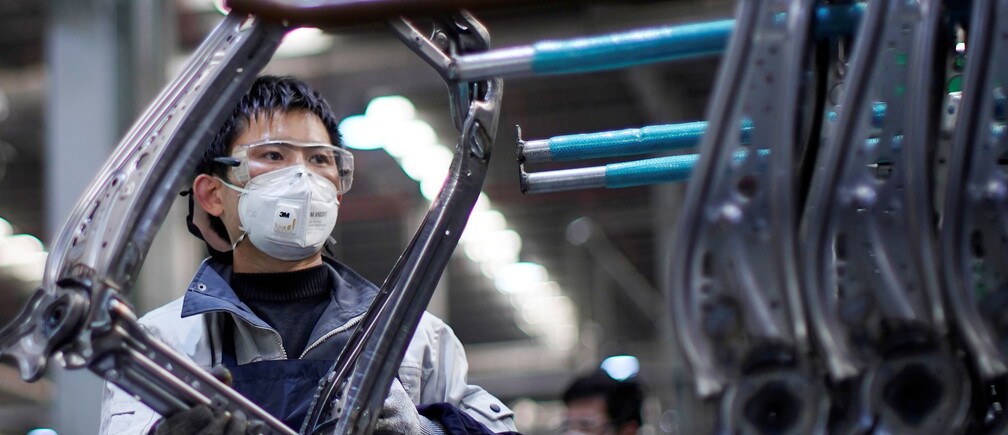An employee wears a face mask to work on a car seat assembly line in Shanghai.
