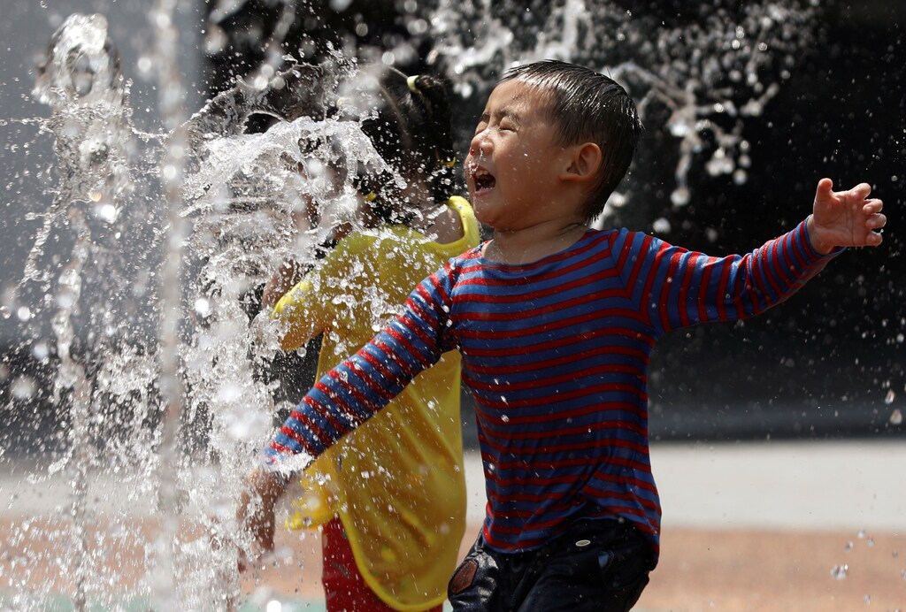 Children play at a water fountain on a hot day in Singapore June 21, 2017. REUTERS/Edgar Su - RC19E7AB2CB0