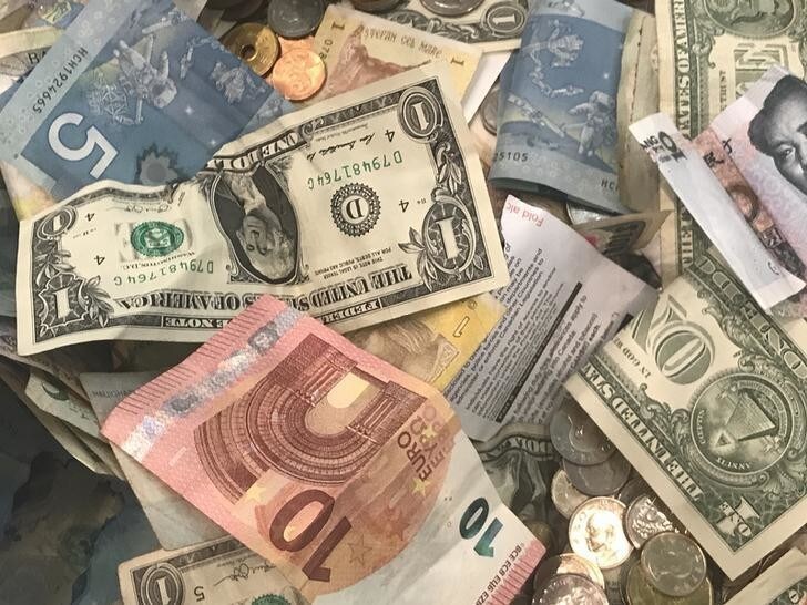 U.S. dollars and other world currencies lie in a charity receptacle at Pearson international airport in Toronto, Ontario, Canada June 13, 2018. REUTERS/Chris Helgren