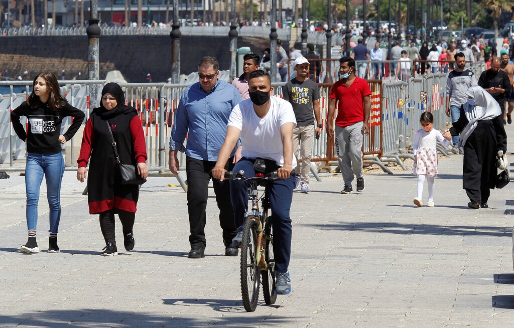 People walk and a man rides a bicycle along Beirut's seaside Corniche, as Lebanese authorities warned of a new wave of the coronavirus disease (COVID-19) as the numbers jumped to the highest point in more than a month, after the government eased some restrictions on public life, in Beirut, Lebanon May 10, 2020. Picture taken May 10, 2020. REUTERS/Mohamed Azakir - RC2FMG9YFT4I