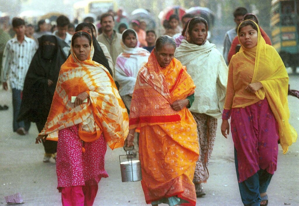 Bangladeshi women walk to work to garment factories in Dhaka: Thanks to industrialization policies, 84% of Bangladeshi export revenues come from apparel alone.