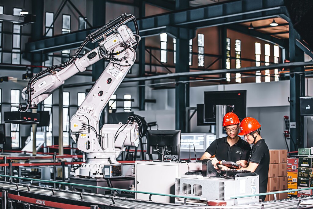 Trabajadores de una fábrica utilizan la tecnología en el proceso de manufactura.