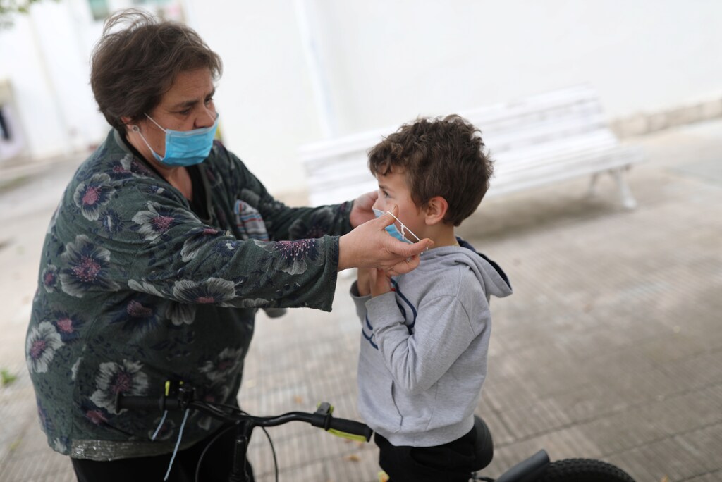 Amparo Aguilera puts a protective face mask on her grandchild Kilian, 6, after restrictions were partially lifted for children, during the coronavirus disease (COVID-19) outbreak, in Igualada, Spain April 26, 2020. REUTERS/Nacho Doce - RC2GCG90NK6P
