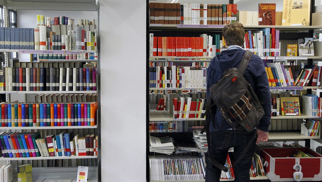 A man looks at books in Goethe Institute's library in Barcelona February 1, 2013. Barcelona's Goethe Institute offers more than 170 German courses every year. In the last two years they have seen the number of students grow by 75 percent, most of them people under 25 who want to seek a better future in Germany, according to the centre director, Marion Haase. Picture taken February 1, 2013. REUTERS/Albert Gea (SPAIN - Tags: BUSINESS EMPLOYMENT EDUCATION) - RTR3DCZ2