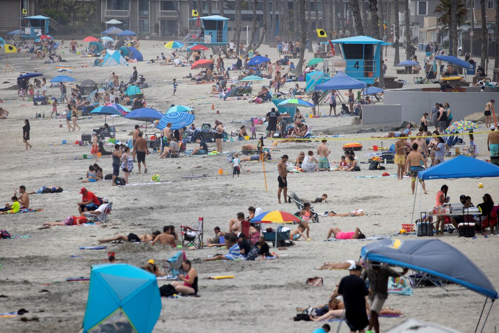 Few people wear masks as they gather at the beach during the global outbreak of the coronavirus disease (COVID-19) in Oceanside, California, U.S., June 22, 2020. REUTERS/Mike Blake - RC2MEH9KTI03