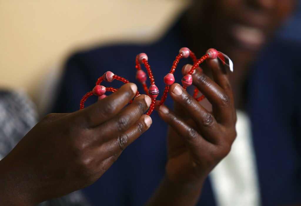 A woman makes a bead bracelet at the Uzima bead-making workshop in the Kangemi slum of Nairobi April 22, 2013. The Jesuit-run Uzima programme cares for people with HIV, providing support groups, counselling, awareness of prevention of mother-to-child transmission, as well as income generating activities such as bead-making. The bead products are sold as far as Italy and Belgium. In 2009, there were 1.5 million people living with HIV in Kenya, with the adult prevalence rate having fallen dramatically since the mid-1990s, according to the African Jesuit AIDS Network. Picture taken April 22, 2013. REUTERS/Darrin Zammit Lupi (KENYA - Tags: SOCIETY HEALTH BUSINESS EMPLOYMENT) - GM1E94U0BEE01