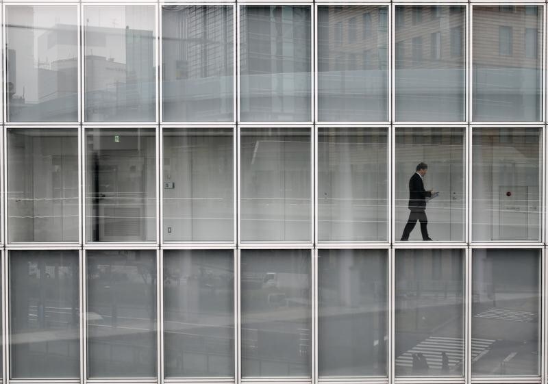 A man walks inside an office building in Tokyo March 19, 2014. Large Japanese firms are growing more confident about weathering the impact of an imminent sales tax increase and they expect further profit rises even after a bumper year, a Reuters poll showed - encouraging signs for an economy that is seeing a sharp slowdown in growth. REUTERS/Yuya Shino (JAPAN - Tags: BUSINESS POLITICS EMPLOYMENT TPX IMAGES OF THE DAY) - RTR3HT6J