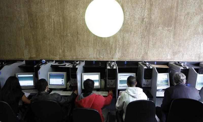 Customers use computers at an internet cafe in Sao Paulo March 3, 2011.