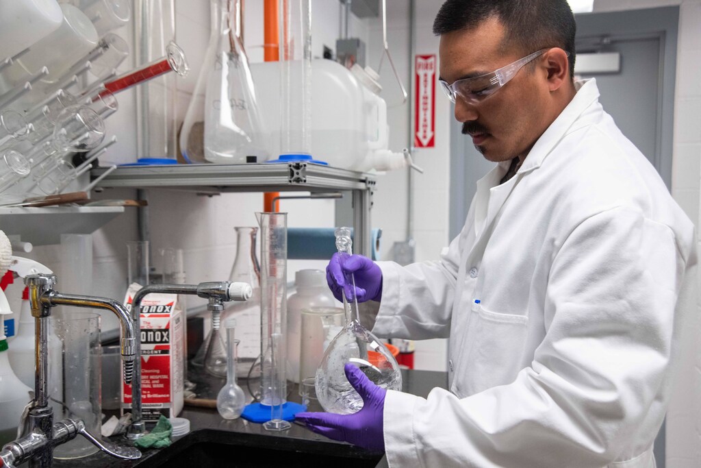 A scientist in a laboratory holding a flask