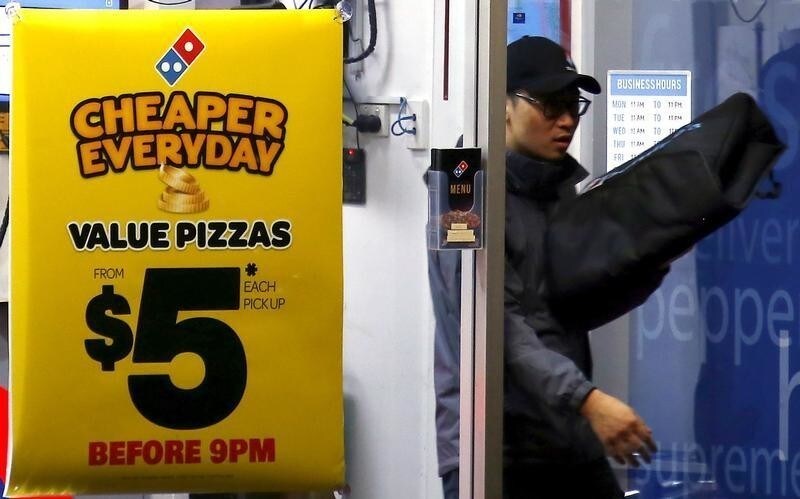 A worker carries a pizza for delivery as he exits a Domino's pizza store in Sydney, Australia, August 12, 2015. Fast food may be falling out of favour in many countries around the world but companies are making healthy profits and boldly innovating in the unlikely market of Australia. Contrary to stereotypes of a beach-going community of fitness fanatics, official data out this week showed 40 percent of Australian adults are dangerously obese and have a poor diet that includes lashings of fast food. That makes Australia a hotbed for innovation by companies including homegrown firm Domino's Pizza Enterprises Ltd, McDonald's Corp and Yum! Brands Inc's, KFC and Pizza Hut as they struggle to win over health-conscious diners in other countries. Picture taken August 12, 2015.