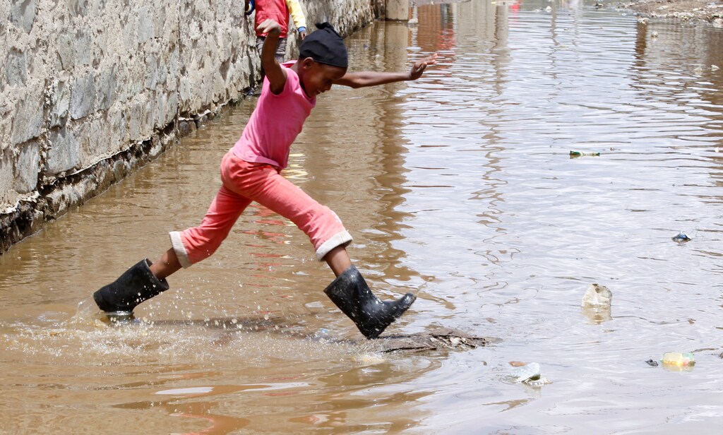 A child jumps as she wades through flood waters after the levels at Lake Naivasha bulged to record high, pushing hundreds of people from surrounding farms around Naivasha town within Nakuru county, Kenya November 8, 2020. Picture taken November 8, 2020. REUTERS/Monicah Mwangi