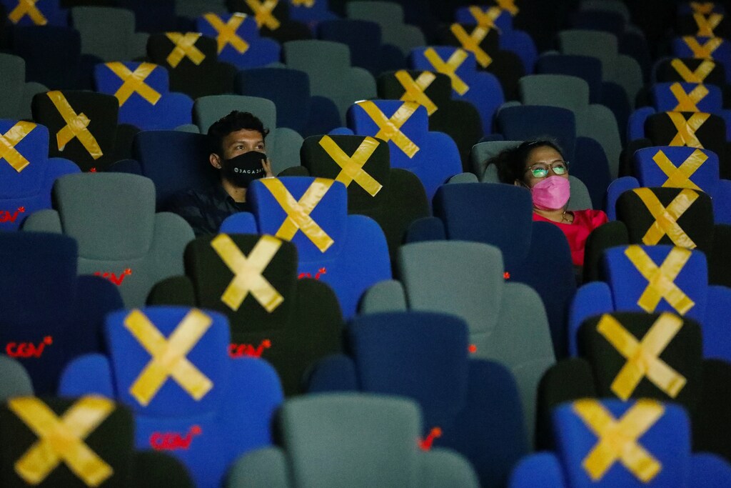 Visitors wearing protective masks watch a movie at a cinema as it is reopened after the ease of restrictions amid the coronavirus disease (COVID-19) pandemic in Jakarta, Indonesia, September 16, 2021. REUTERS/Willy Kurniawan - RC2VQP9LHOM0